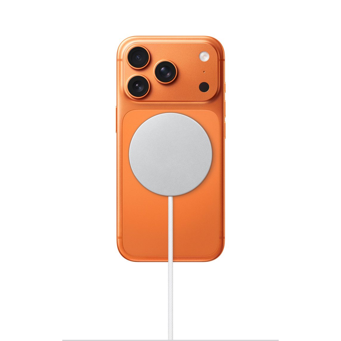 Apple iPhone 17 Pro Max в цвете Cosmic Orange с пристёгнутым магнитным зарядным диском MagSafe на задней панели